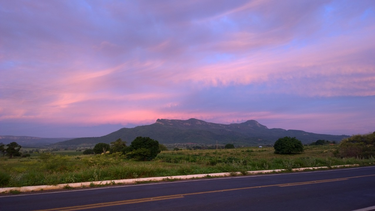 Serra Geral ao amanhecer, vista da MG-122 entre Mato Verde e Monte Azul, sob céu rosa e lilás.